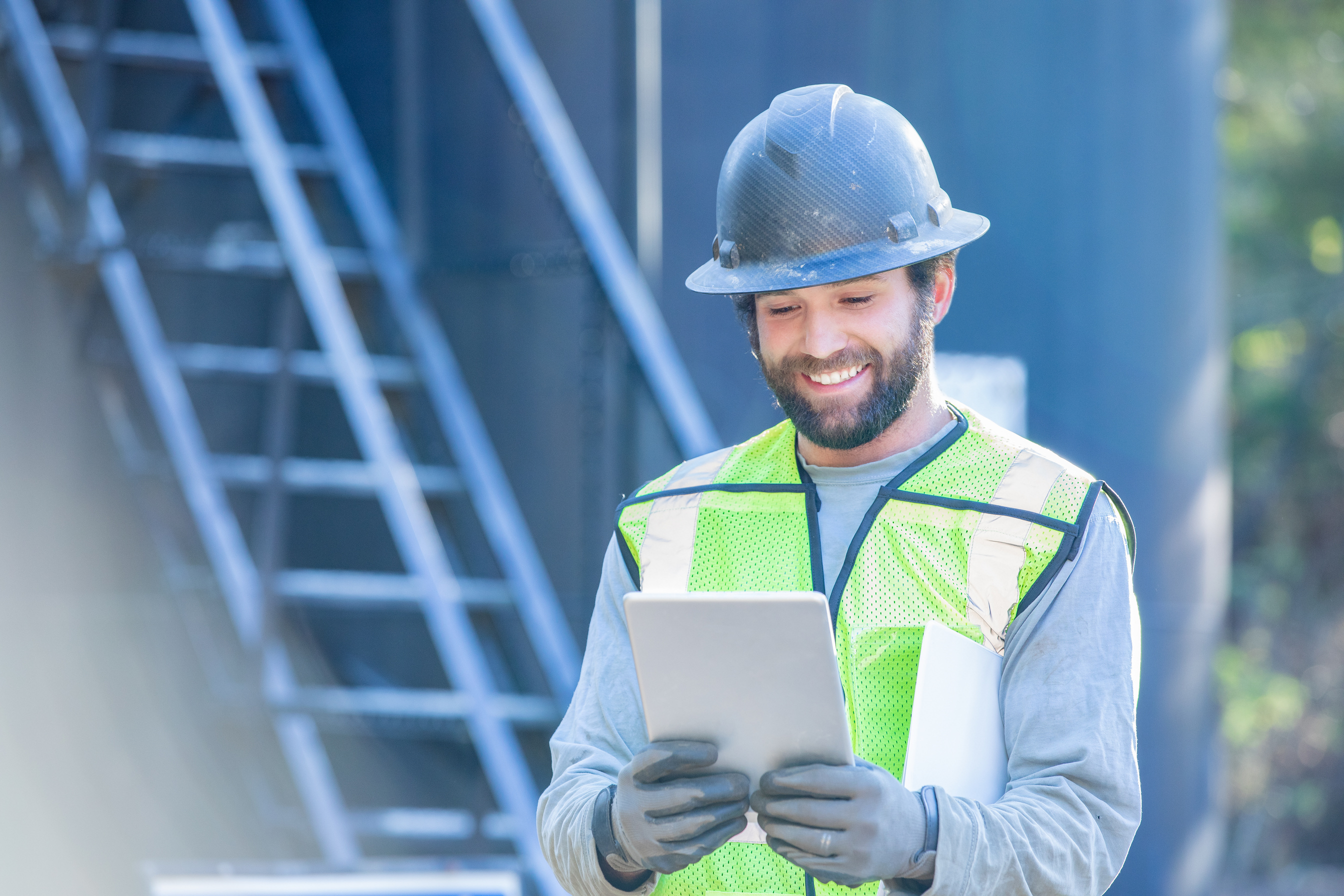 Oil and gas industry worker using digital tablet on gas well or oil lease